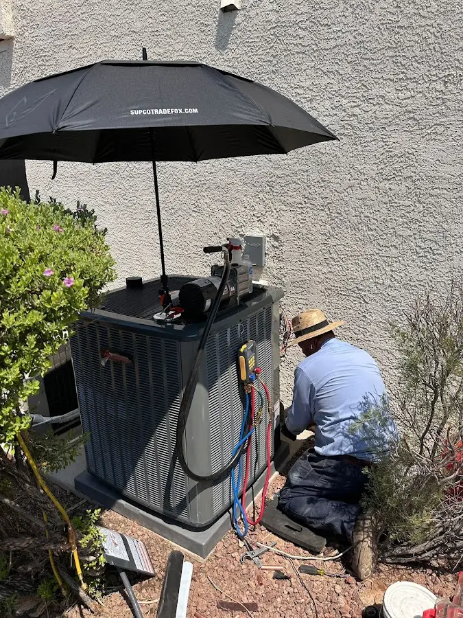 HVAC technician performing outdoor AC maintenance in Hamlet