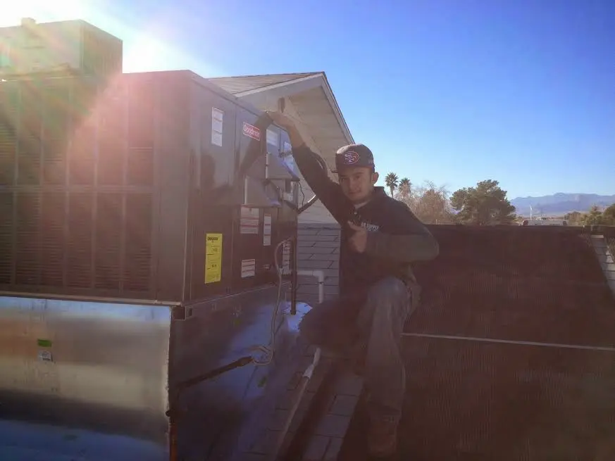 HVAC technician performing AC Tune-Up on a rooftop unit in Hamlet